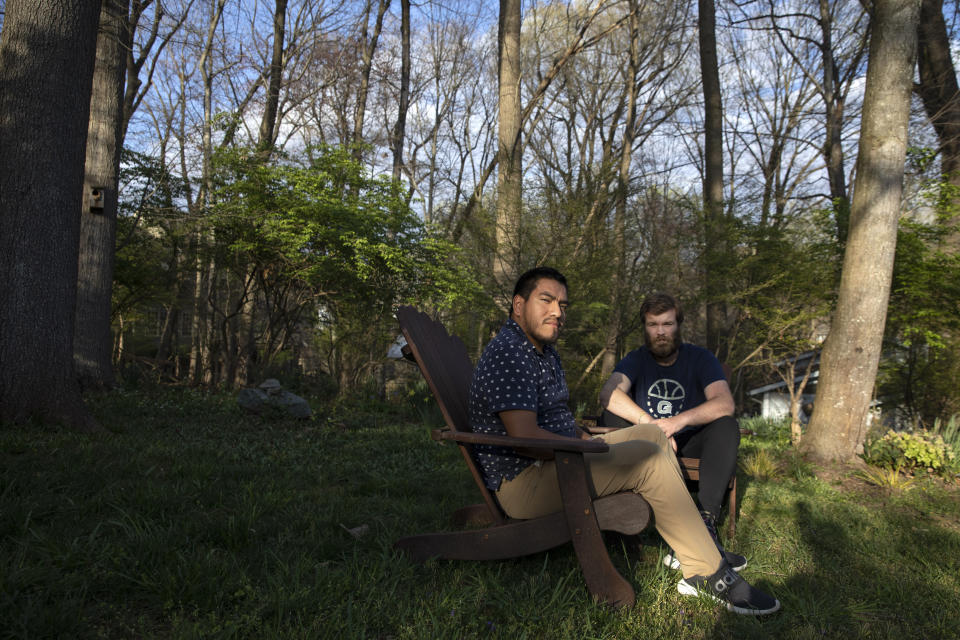 Jakob Leichtman, 23, left, and Jack Cashmere, 22, who were serving together in the Peace Corps in Ecuador for two months and were awaiting their first placements when the Peace Corps evacuated them due to coronavirus concerns, pose for a portrait outside of Cashmere's parents home in Bethesda, Md., Wednesday April 1, 2020, where the two are finishing their quarantine period together. Leichtman preferred to quarantine with Cashmere rather than put his father who is 72 at risk. (AP Photo/Jacquelyn Martin)