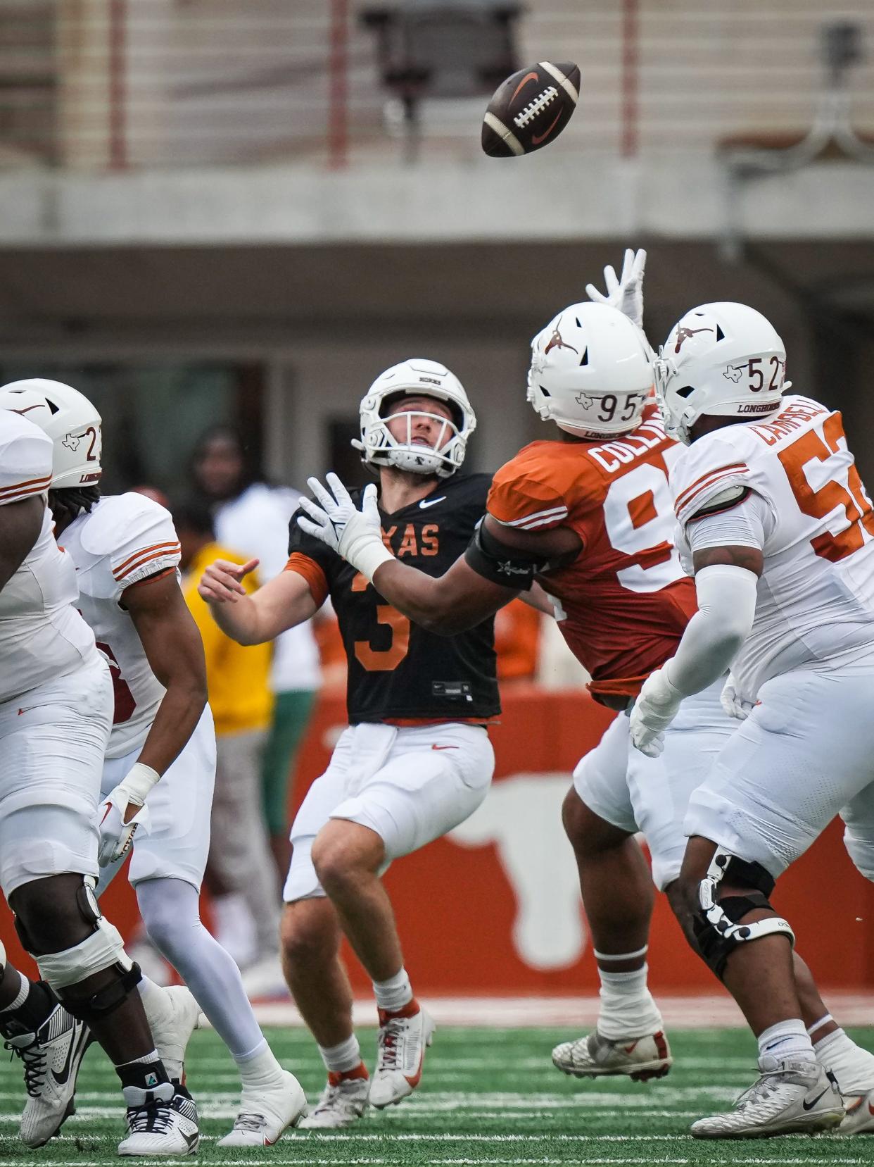 Texas defensive lineman Alfred Collins, center, keeps an eye on a batted ball that he eventually caught and returned for a touchdown in Saturday's Orange-White game. Collins was arguably the most impressive defensive tackle during the spring.