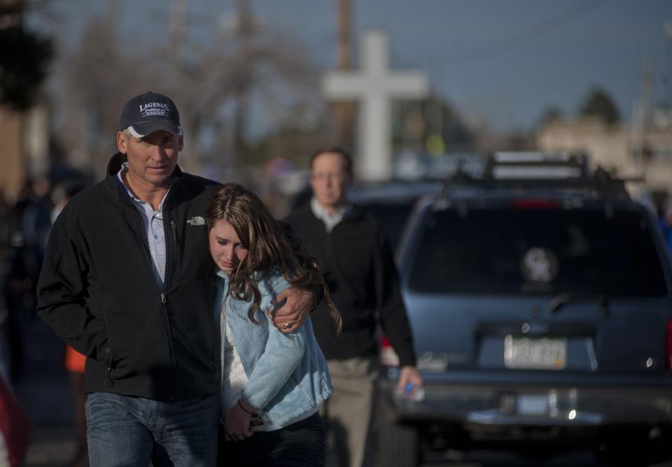 A man hugs his daughter after she was escorted out of Arapahoe High School, following a shooting incident where a student opened fire in the school in Centennial, Colorado