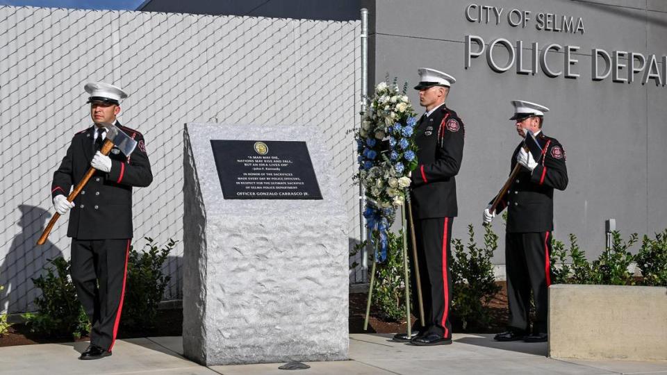 Members of the Selma Fire Department present a wreath next to a memorial dedicated to fallen Selma Police Officer Gonzalo Carrasco Jr. who was killed in the line of duty one year ago, at the Selma Police Department on Wednesday, Jan. 31, 2024. CRAIG KOHLRUSS/ckohlruss@fresnobee.com