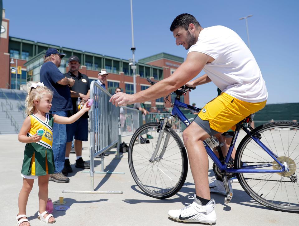 Green Bay Packers tight end Tyler Davis takes up Aria Rubens on her offer to have a sip of pretend tea after Wednesday's practice. It was the De Pere toddler's third time at training camp.