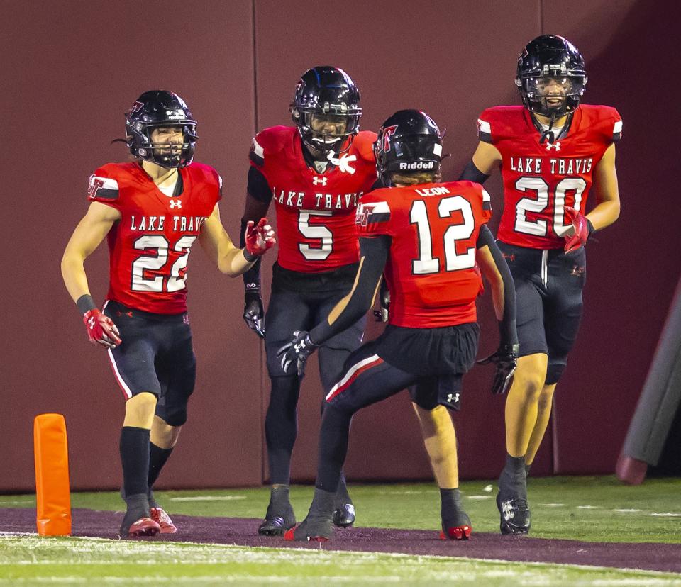 Lake Travis defensive back Josiah Estes, back center, gets kudos from teammates after his 77-yard touchdown in the Nov. 17 playoff win over San Antonio Johnson. The Cavaliers will play a rematch against District 26-6A rival Westlake in the fourth round of the Class 6A state playoffs this weekend.