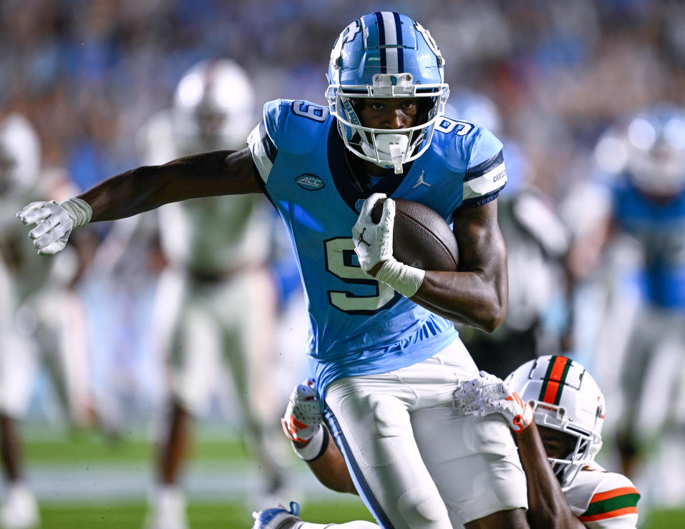 CHAPEL HILL, NORTH CAROLINA – OCTOBER 14: Devontez Walker #9 of the North Carolina Tar Heels breaks away from <a class="link " href="https://sports.yahoo.com/ncaaf/players/322653/" data-i13n="sec:content-canvas;subsec:anchor_text;elm:context_link" data-ylk="slk:Kamren Kinchens;sec:content-canvas;subsec:anchor_text;elm:context_link;itc:0">Kamren Kinchens</a> #5 of the Miami Hurricanes for a touchdown during the second half of their game at Kenan Memorial Stadium on October 14, 2023 in Chapel Hill, North Carolina. The Tar Heels won 41-31. (Photo by Grant Halverson/Getty Images)