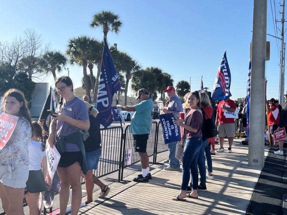 A cheering crowd lines Orange Avenue, trying for a glimpse of former President Trump in his motorcade arriving at the federal courthouse for a closed hearing in his criminal documents case.