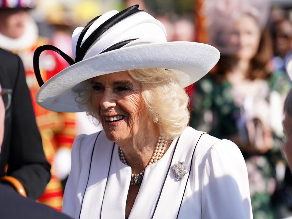 LONDON, ENGLAND - MAY 8: Queen Camilla speaks to guests attending a Royal Garden Party at Buckingham Palace on May 8, 2024 in London, England.  (Photo by Jordan Pettitt - Pool/Getty Images)