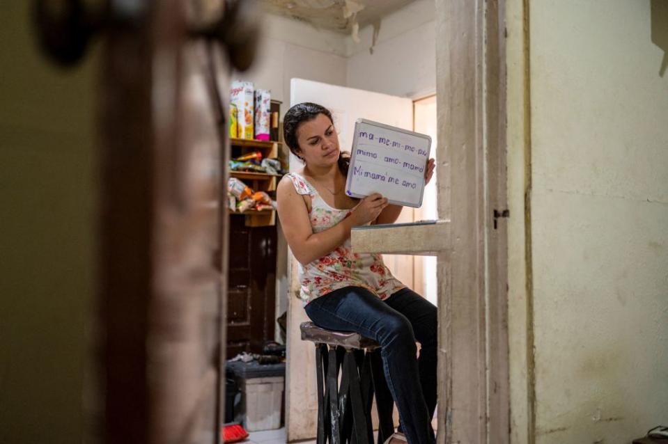 Gabriela Fajardo holds up a white board during an online class she teaches from her home in Matamoros, Mexico, on May 25, 2021.<span class="copyright">Sergio Flores—AFP/Getty Images</span>