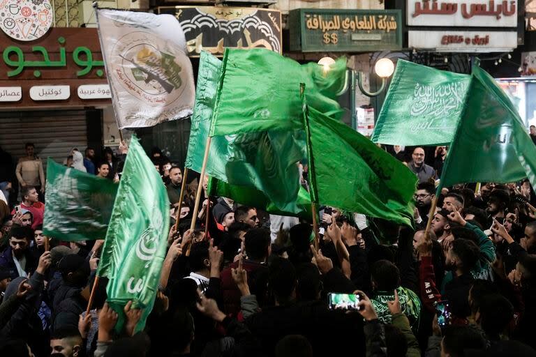 Palestinos ondean banderas de Hamás mientras celebran la liberación de prisioneros palestinos el viernes 24 de noviembre de 2023, en Naplusa, Cisjordania. (AP Foto/Majdi Mohammed)