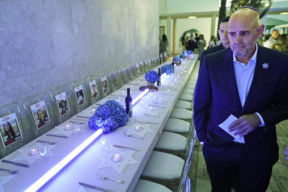 Consul General of Israel in Miami Maor Elbaz-Starinsky looks at an empty Shabbat table honoring those kidnapped by Hamas in Israel, Thursday, Nov. 2, 2023, at Temple Beth Sholom in Miami Beach, Fla. The holiday of Hanukkah, Judaism's festival of lights, will be both more needed and more poignant than ever this year, say Jews from across the religious observance and political spectrum in Miami Beach and neighboring South Florida communities. (AP Photo/Wilfredo Lee)