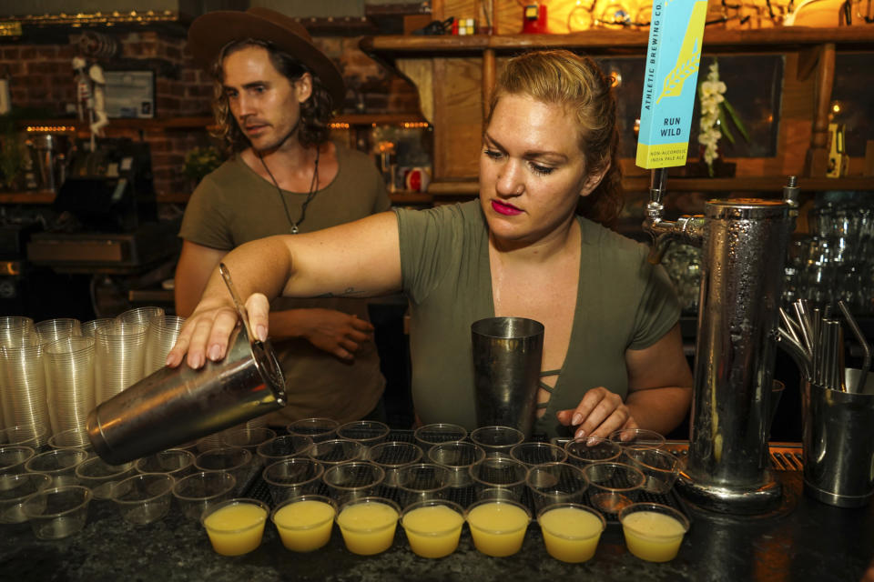 This undated image released by Sasha Charoensub shows bartenders Matthew Bray, left, looking on while Crystal Chasse preparing mocktails at Listen bar in New York. Alcohol-free bars serving elevated “mocktails” are attracting more young people than ever before. Regular bars and restaurants are cluing into the idea that alcohol-free customers want more than a splash of cranberry with a spritz. The interest is also driven by the wellness movement and higher quality ingredients. (Sasha Charoensub/Listen Bar via AP)