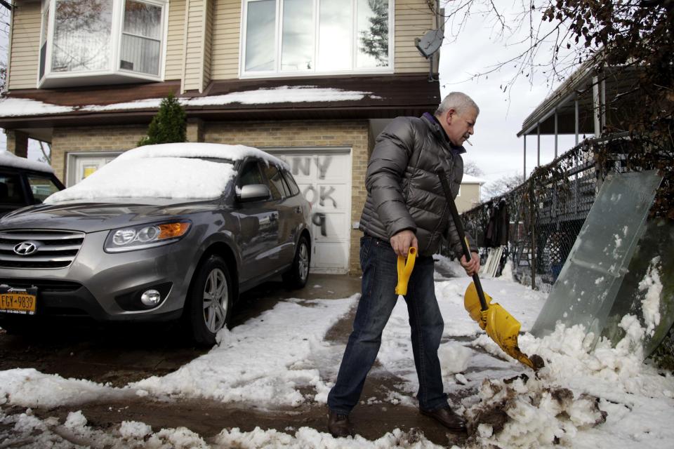 Gennady Naydis keeps clearing his driveway even as the handle breaks off his shovel in the New Dorp section of Staten Island, N.Y., Thursday, Nov. 8, 2012. The New York-New Jersey region woke up to a layer of wet snow and more power outages after a new storm pushed back efforts to recover from Superstorm Sandy. (AP Photo/Seth Wenig)