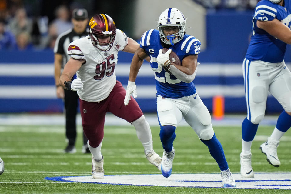 Indianapolis Colts running back Jonathan Taylor (28) runs past Washington Commanders defensive end Casey Toohill (95) in the first half of an NFL football game in Indianapolis, Sunday, Oct. 30, 2022. (AP Photo/AJ Mast)