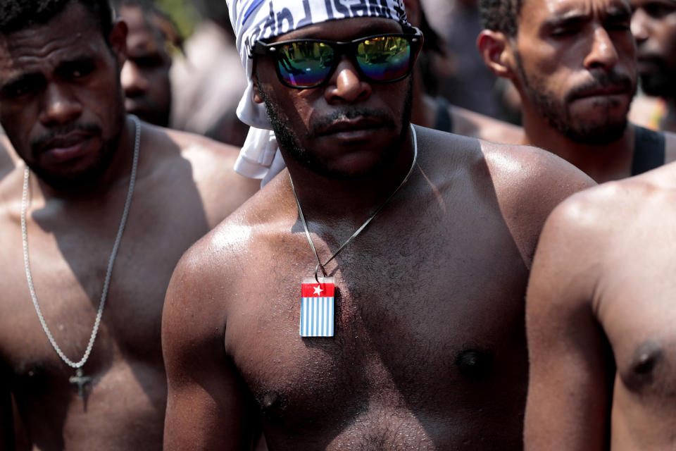 A Papuan activist wears a necklace separatist 'Morning Star' flag during a rally near the presidential palace in Jakarta, Indonesia, Thursday, Aug. 22, 2019. A group of West Papuan students in Indonesia's capital staged the protest against racism and called for independence for their region. (AP Photo/Dita Alangkara)