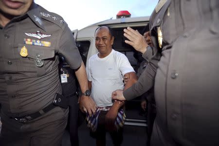 Patchuban Angchotipan, a suspected kingpin of a human trafficking network, is escorted by policemen at Hat Yai police station May 18, 2015. REUTERS/Stringer