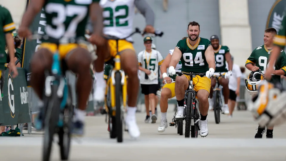 Green Bay Packers defensive lineman Dean Lowry (94), the former Boylan star from Rockford, smiles as he rides a bike to the first day of training camp July 27, 2022, in Green Bay, Wis.