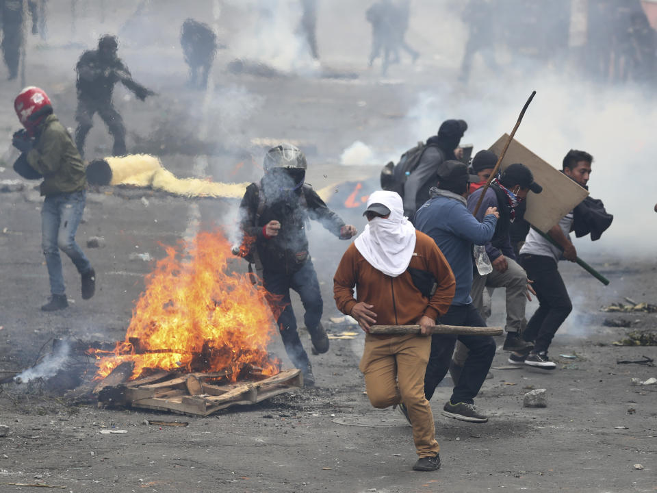 Manifestantes opuestos al gobierno huyen de la policía durante enfrentamientos en Quito, Ecuador, el viernes 11 de octubre de 2019. (AP Foto/Dolores Ochoa)