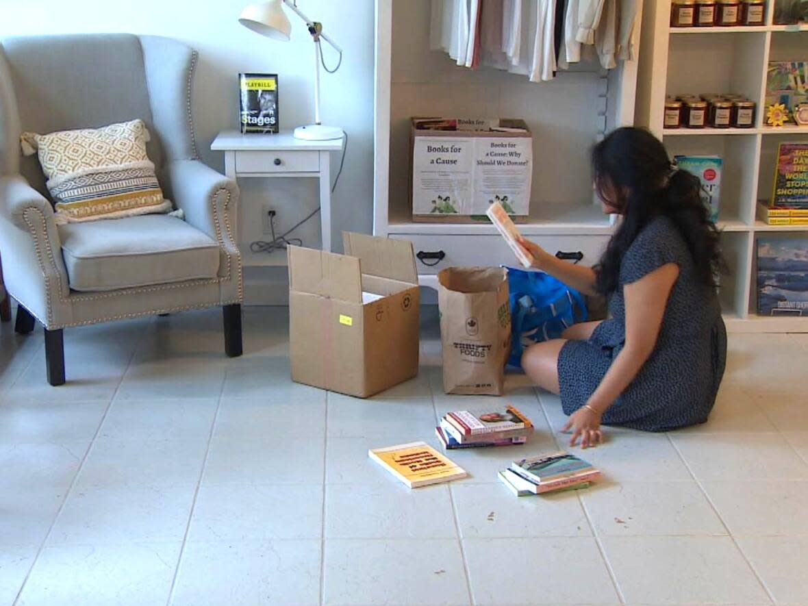 Chloe Chen, Fair Books founder, sorts through prison book donations (Martin Diotte/CBC - image credit)