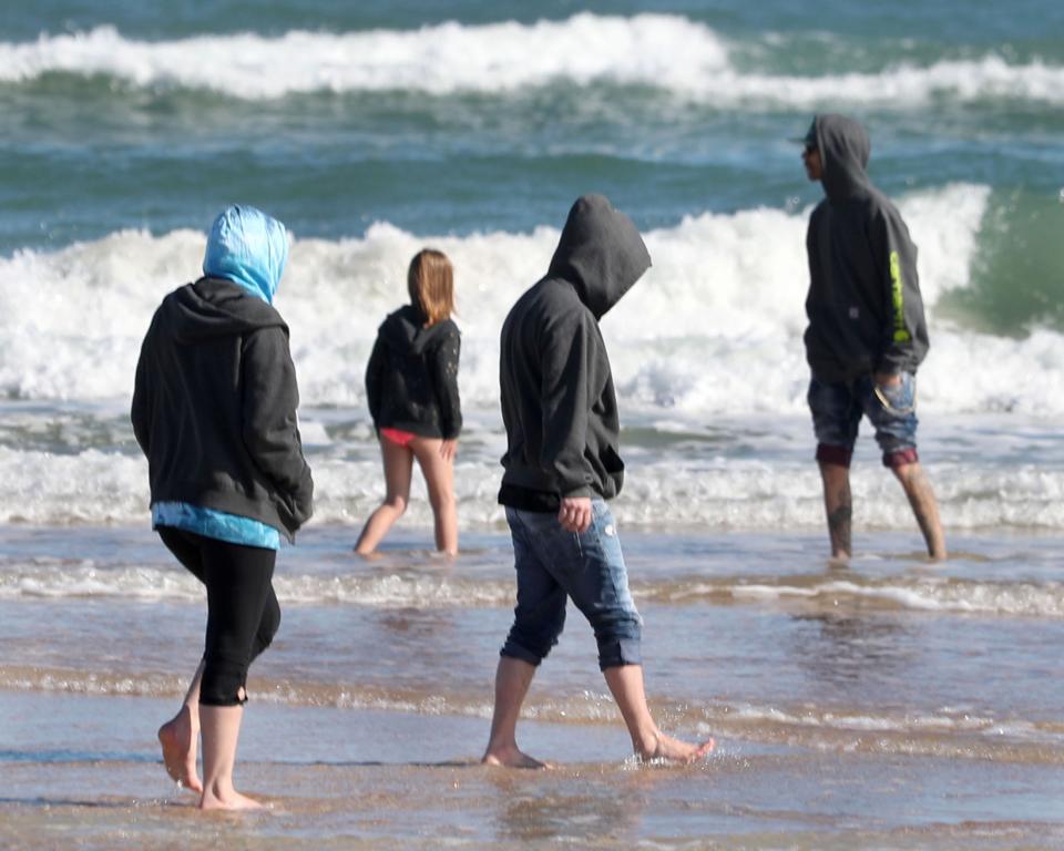 Beachgoers in hoodies and jackets waded in the surf near Sun Splash Park in Daytona Beach in January 2022 as a cold front blew in.