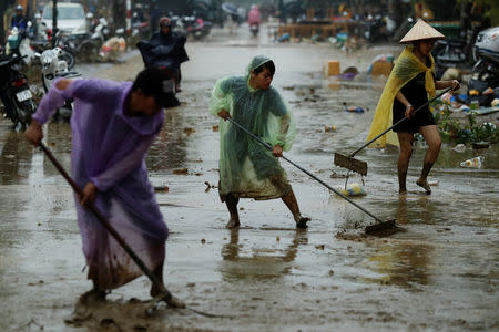 People clean mud from a street caused by flooding by Typhoon Damrey, in the ancient UNESCO heritage town of Hoi An, Vietnam November 8, 2017. REUTERS/Jorge Silva