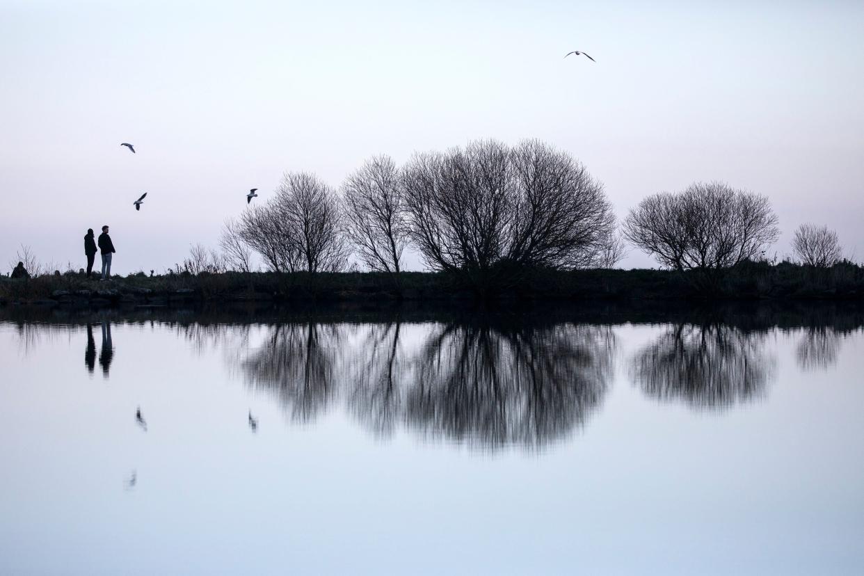 A couple are pictured on a walk in Holyrood Park, Edinburgh, on 30 November, 2020.  (PA)