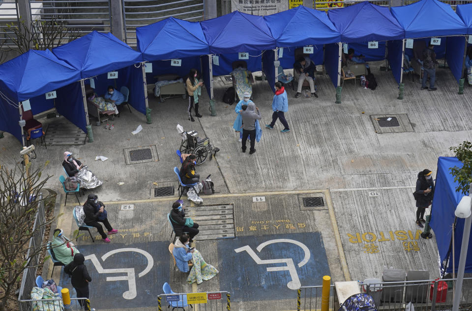 People, including current hospital patients, showing COVID-19 symptoms wait at a temporary holding area outside Caritas Medical Centre in Hong Kong Wednesday, Feb. 16, 2022. China's leader Xi Jinping took a personal interest in Hong Kong's outbreak, saying it was the local government's "overriding task" to control the situation, a Hong Kong newspaper said on Wednesday. (AP Photo Vincent Yu)