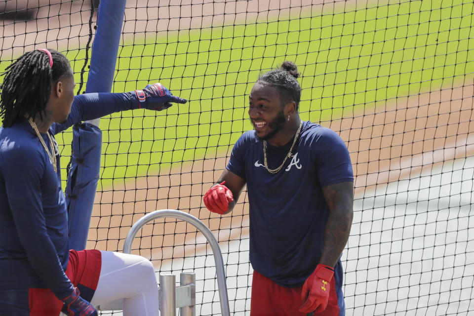 Atlanta Braves' Ozzie Albies, right, laughs with Ronald Acuña Jr. before batting during team baseball practice at Truist Park, Sunday, July 5, 2020, in Atlanta. (AP Photo/Brynn Anderson)