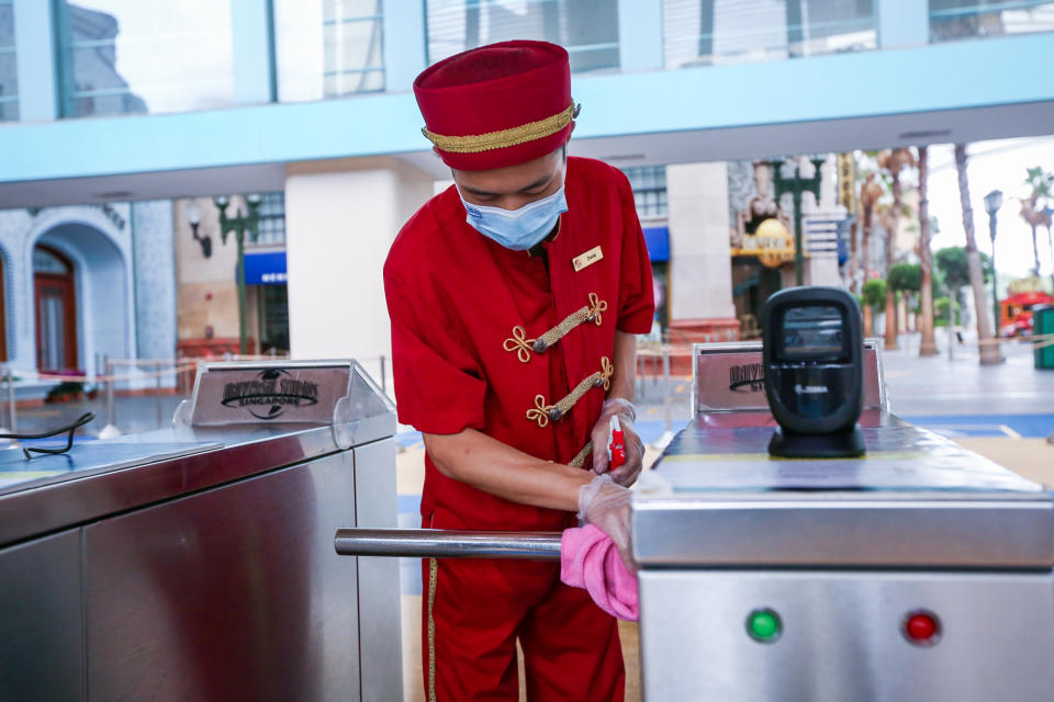 A posed photo of a Universal Studios Singapore employee cleaning an entry gate. Resorts World Singapore attractions on Sentosa, including Universal Studios Singapore and the S.E.A. Aquarium, will reopen in Phase 2 of Singapore's reopening during the COVID-19 pandemic. (Photo: RWS)