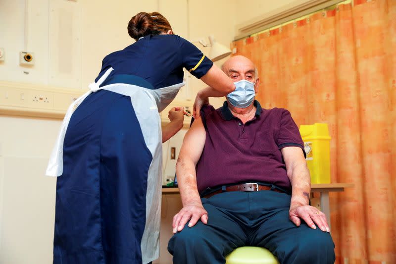 Brian Pinker, 82, receives the Oxford University/AstraZeneca COVID-19 vaccine at the Churchill Hospital in Oxford