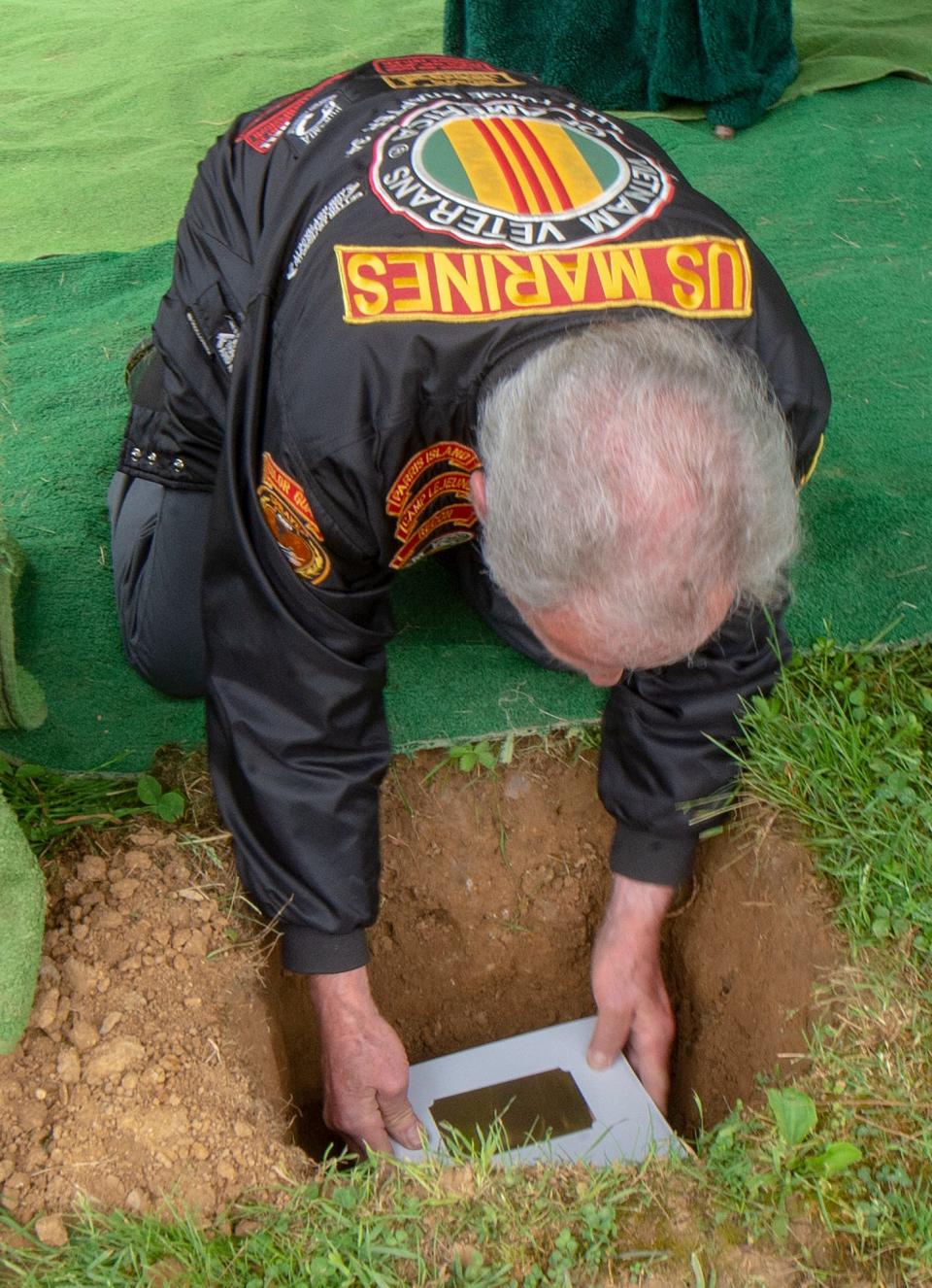 Vietnam War veteran Sgt. Joe Caracappa, member of DAV Chapter 25, of Roxboro, places the remains of veteran John Williams, into the plot next to the deceased's mother, Evelyn Williams, at the Fairview Cemetery in Willow Grove, on Friday, May 27, 2022.