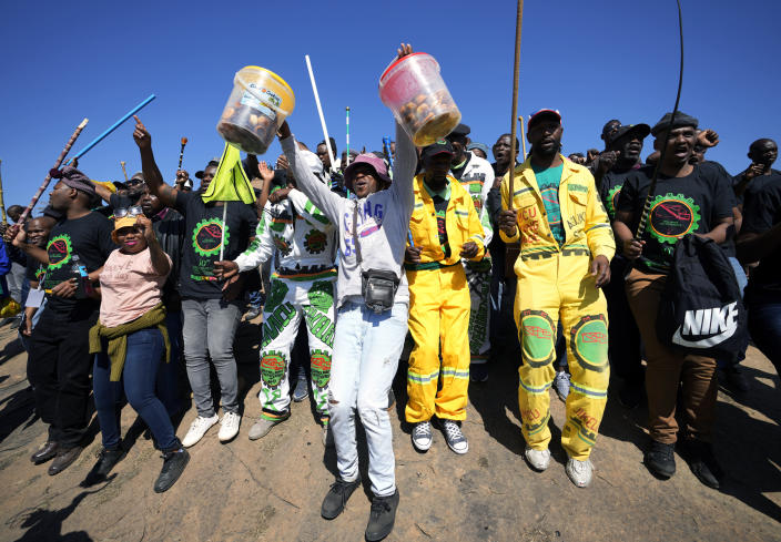 Mine workers sing as they wait for the start of commemoration ceremonies near Marikana in Rustenburg, South Africa, Tuesday, Aug. 16, 2022. South Africa marks on Tuesday 10 years since the Marikana massacre, where 44 people were killed during a mine strike at a platinum mine near Rustenburg, North West province. (AP Photo/Themba Hadebe)