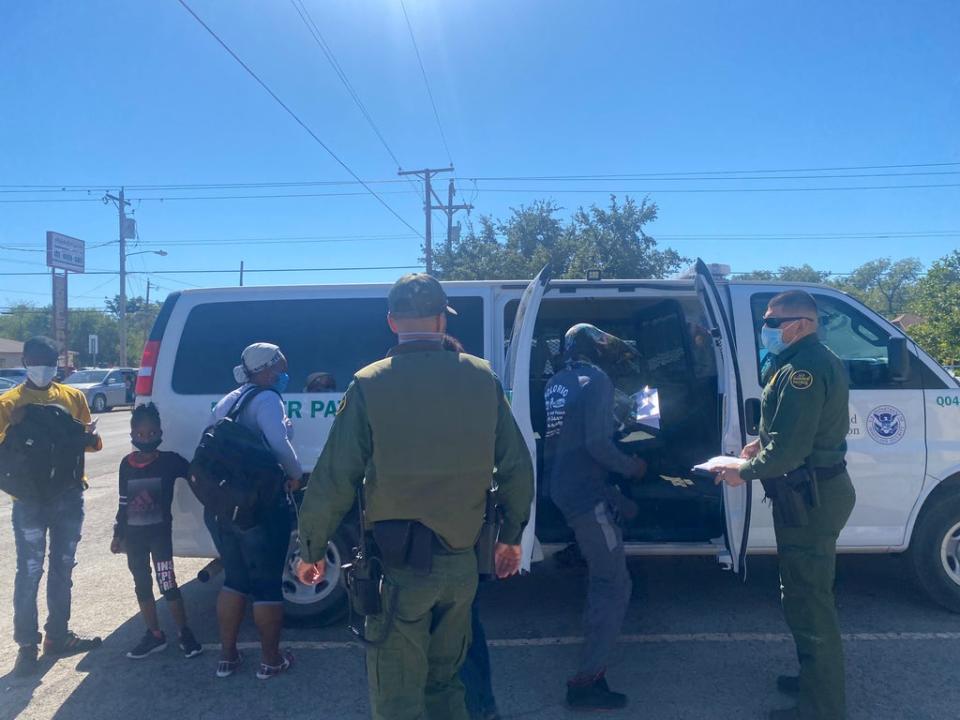 A border patrol bus drops off migrants at a transfer centre in Del Rio (Richard Hall/The Independent)