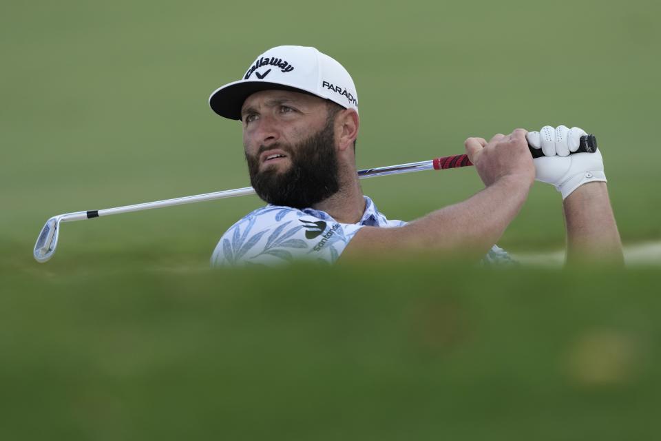 Jon Rahm from Spain plays a bunker shot on the first hole during the round three of the DP World Tour Championship golf tournament, in Dubai, United Arab Emirates, Saturday, Nov. 18, 2023. (AP Photo/Kamran Jebreili)