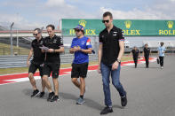 Alpine driver Fernando Alonso, second from right, of Spain, walks the course with his crew before the Formula One U.S. Grand Prix auto race at the Circuit of the Americas, Thursday, Oct. 21, 2021, in Austin, Texas. (AP Photo/Nick Didlick)