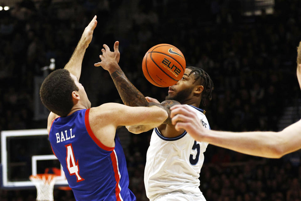 American guard Lincoln Ball (4) is fouled by Villanova guard Justin Moore (5) during the first half of an NCAA college basketball game, Monday, Nov. 6, 2023, in Villanova, Pa. (AP Photo/Laurence Kesterson)