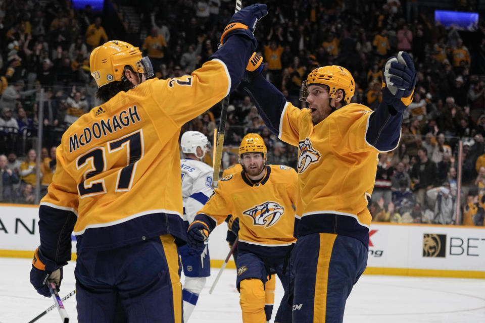 Nashville Predators left wing Cole Smith, right, congratulates defenseman Ryan McDonagh (27) after scoring a goal against the Tampa Bay Lightning during the second period of an NHL hockey game Thursday, Dec. 7, 2023 in Nashville, Tenn. (AP Photo/George Walker IV)