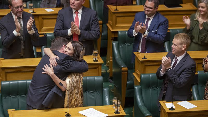 Jacinda Ardern, second left, is hugged by Finance Minister Grant Robertson after Ardern made her final speech to New Zealand’s Parliament in Wellington, on Wednesday, April 5, 2023, after her five-year tenure as prime minister.