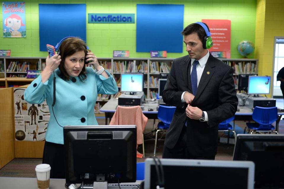 In this 2015 file photo, State Rep. Tricia Cotham and then-State Sen. Jeff Jackson try on green headphones for a photo in the media center before heading out on the tour of Shamrock Gardens Elementary in Charlotte. At the time, both were Democrats representing Mecklenburg County in the legislature. Now, after Cotham flipped to the GOP, Jackson asked for and received a campaign donation back.