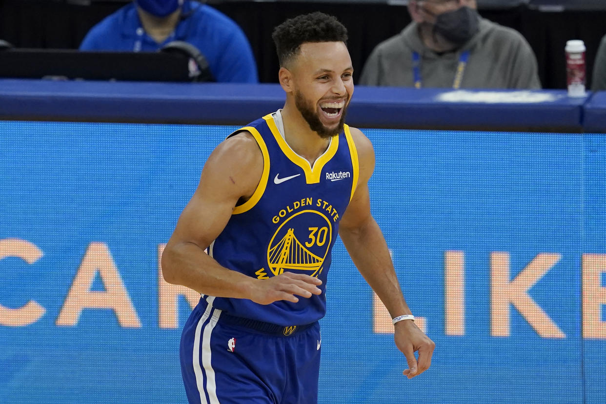 Stephen Curry smiles wide during a game.