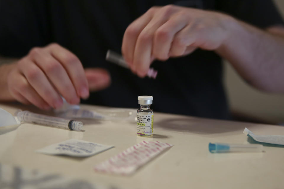 Lucas prepares his weekly testosterone shot at his home in Casselberry, Fla., May 29, 2023. The Associated Press is not using Eli’s and Lucas’ last names because they fear reprisal. After Gov. Ron DeSantis signed a new law preventing nurse practitioners from providing gender affirming care, thousands of trans adults in Florida lost access to their providers and medications without warning, including Lucas. (AP Photo/Laura Bargfeld)