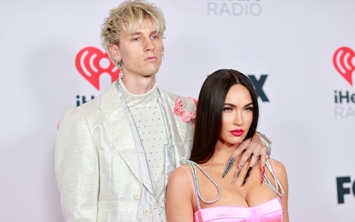 Megan Fox und ihre Verlobter Machine Gun Kelly tauschten die Haarfarbe und wargen sich in coole Klamotten, um auszusehen wie eines der berühmtesten Pärchen der 90er-Jahre: Pamela Anderson und Rocker Tommy Lee.  (Bild: 2021 [iHeartMedia]/Emma McIntyre)