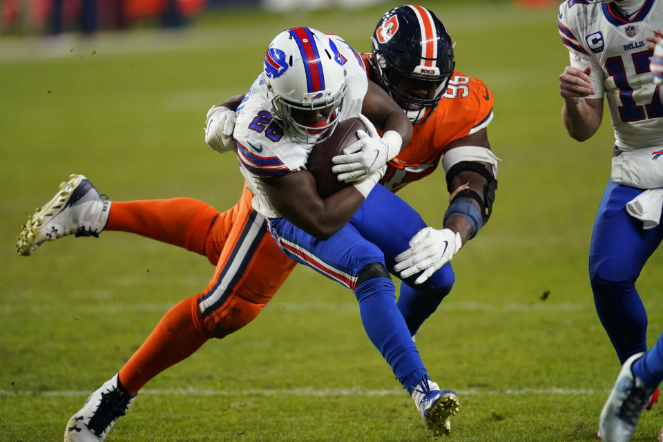 Buffalo Bills running back Devin Singletary runs with the ball as Denver Broncos defensive end Shelby Harris defends during the second half of an NFL football game Saturday, Dec. 19, 2020, in Denver. (AP Photo/David Zalubowski)