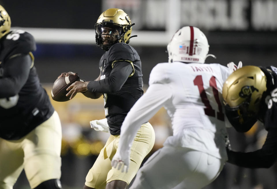 Colorado quarterback Shedeur Sanders looks to pass the ball as Stanford linebacker Tevarua Tafiti defends during the first half of an NCAA college football game Friday, Oct. 13, 2023, in Boulder, Colo. (AP Photo/David Zalubowski)