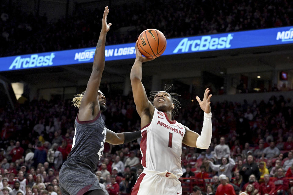 Arkansas guard JD Notae (1) shoots as Texas A&M guard Tyrece Radford (23) defends during the first half of an NCAA college basketball game Saturday, Jan. 22, 2022, in Fayetteville, Ark. (AP Photo/Michael Woods)