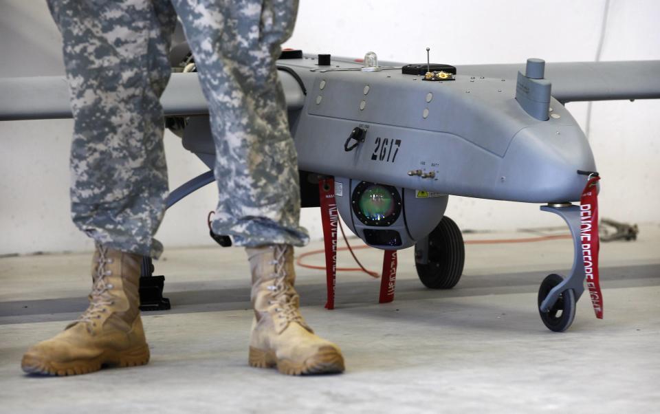 A soldier stands in front of a 'Shadow' Unmanned Aerial System during an official presentation by the German and U.S. Unmanned Aerial Systems (UAS) at the U.S. military base in Vilseck-Grafenwoehr October 8, 2013. The drone has a wing-spread of 6.90 metre, an aircraft speed of about 177 km/h and it's mainly used in Afghanistan. REUTERS/Michaela Rehle (GERMANY - Tags: MILITARY TPX IMAGES OF THE DAY)