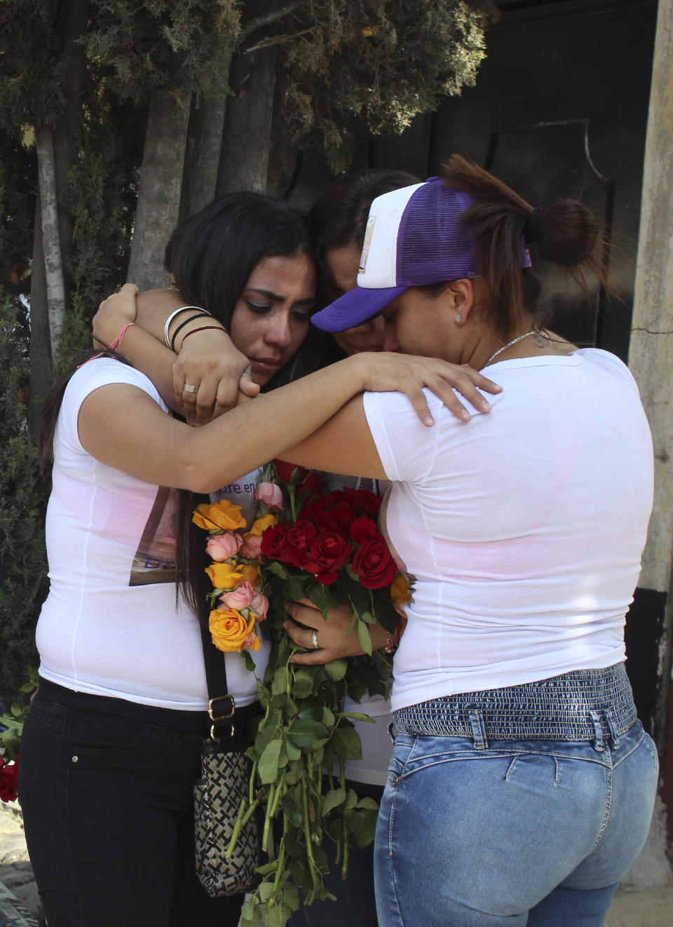 Teresa, from left, Maria and Thalia Carreno embrace during a ceremony in remembrance of their sister Briseida who was killed a year ago, in Ecatepec, a suburb of Mexico City, Saturday, Nov. 23, 2019. Ecatepec is ground zero in the country for gender-related killings of women known as feminicides. On average, 10 women are murdered each day in Mexico, making it one of the most dangerous places in the world to be female. (AP Photo/Amy Guthrie)