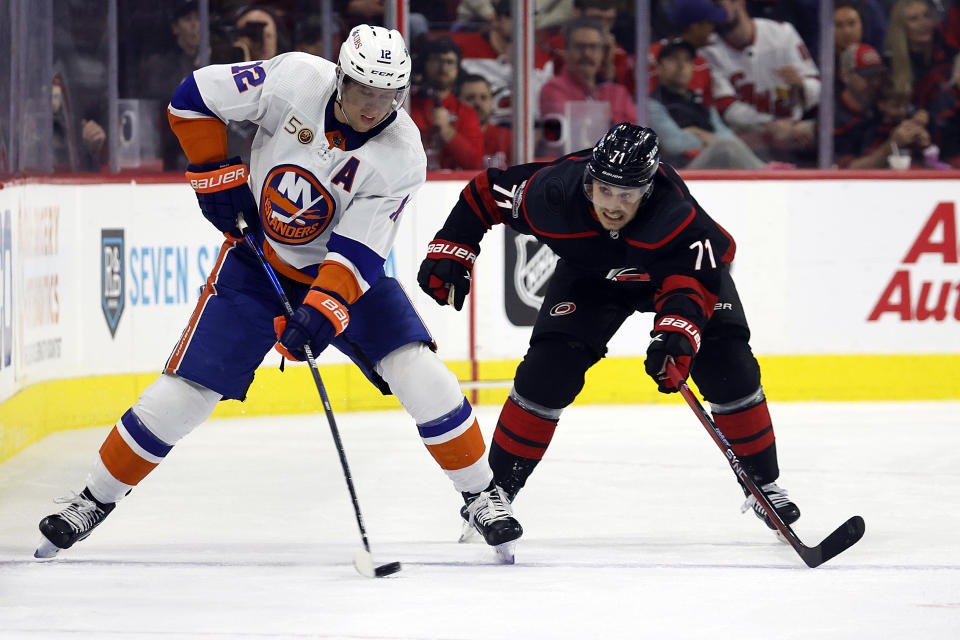 New York Islanders' Josh Bailey (12) tries to pass the puck around Carolina Hurricanes' Jesper Fast (71) during the third period of an NHL hockey game in Raleigh, N.C., Sunday, April 2, 2023. (AP Photo/Karl B DeBlaker)