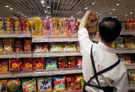 A store assistant arranges Japanese snacks at a supermarket in Singapore October 6, 2016. REUTERS/Edgar Su