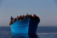 Migrants on a wooden boat await rescue by the Malta-based NGO Migrant Offshore Aid Station (MOAS) in the central Mediterranean in international waters off the coast of Sabratha in Libya, April 15, 2017. REUTERS/Darrin Zammit Lupi