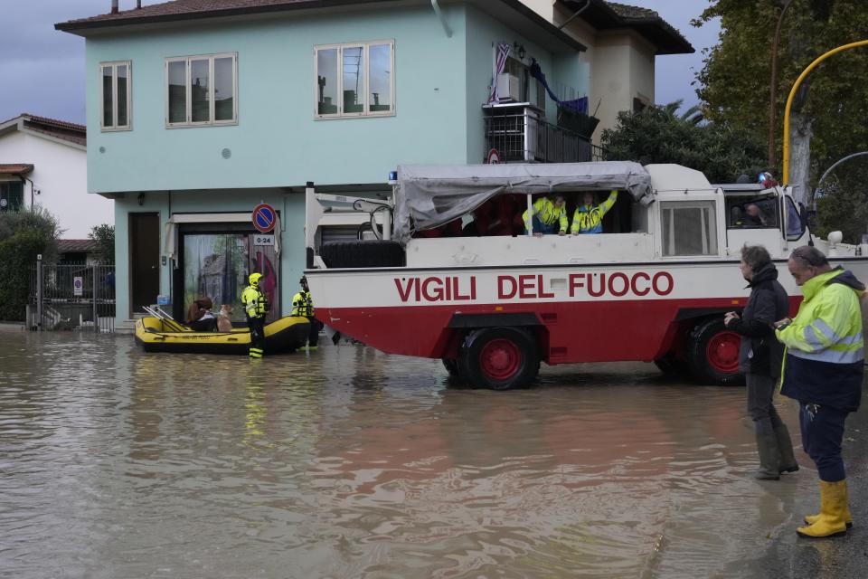 Firefighters rescue a resident in Campi di Bisenzio, in the central Italian Tuscany region, Friday, Nov. 3, 2023. Record-breaking rain provoked floods in a vast swath of Tuscany as storm Ciaran pushed into Italy overnight Friday, trapping people in their homes, inundating hospitals and overturning cars. At least three people were killed, and four were missing. (AP Photo/Gregorio Borgia)