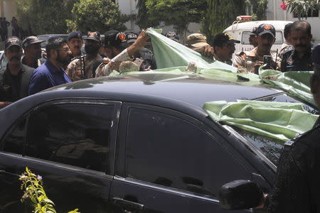 Police look at the bullet holes in the car of Abdul Rashid Godil, a member of the Muttahida Qaumi Movement (MQM) after he was shot, at a hospital in Karachi, Pakistan, August 18, 2015. REUTERS/Athar Hussain