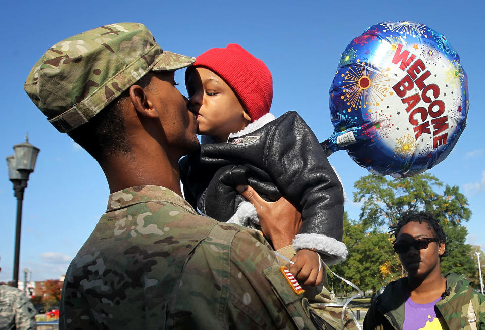 Spc. Marqes Turpin of the 273rd Military Police Company of DC Army National Guard kisses his two-year-old son Josiah Turpin as his sister Nikilae looks on during a homecoming ceremony on Oct. 16, 2012, at the DC National Guard Armory in Washington, DC.